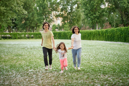 Smiling Family Running Across Summer Field Together. Mother Daughter son, hands together High quality photoの写真素材