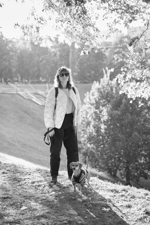 Owner walking with dog together in park outdoors, summer vacation, Adorable domestic pet concept, Friendship between human and their pet. Dachshund in sweater High quality photoの写真素材