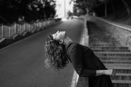 Cropped closeup portrait of a caucasian mature beautiful woman wife looking at the sun in park outdoors streets hiding from the sunset sun in sad serious mood. High quality photoの写真素材