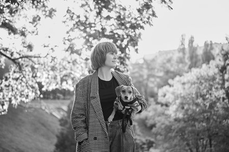 Owner walking with dog together in park outdoors, summer vacation, Adorable domestic pet concept, Friendship between human and their pet. Dachshund in sweater High quality photoの写真素材