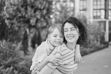 young mother and son smiling looking at the camera in modern residential complex. Having fun...