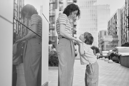 Adorable mother and son smiling happy having fun at city background. Motherhood concept, hugging....