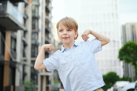 Handsome smiling little boy on the sunny urban background . Close-up portrait. Blond hair, blue eyes , 9 years boy smiling, having fun in the city. High quality photoの写真素材