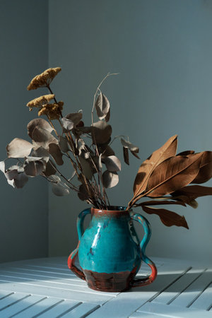 Aesthetic home interior decoration, vase with branches on table, empty white wall with sunlight shadows, lifestyle neutral elegant still life. High quality photoの写真素材
