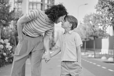 Adorable mother and son smiling happy having fun at city background. Motherhood concept, hugging....