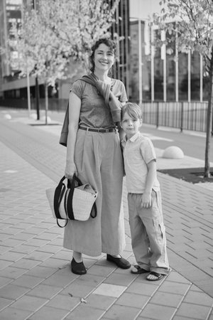 Caucasian young beautiful happy mother and cute small son walking the street and looking at each other. Woman and little boy smiling, talking and having vacations. High quality photoの写真素材