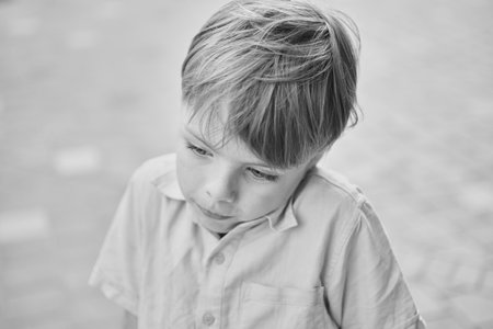 Handsome smiling little boy on the sunny urban background . Close-up portrait. Blond hair, blue eyes...