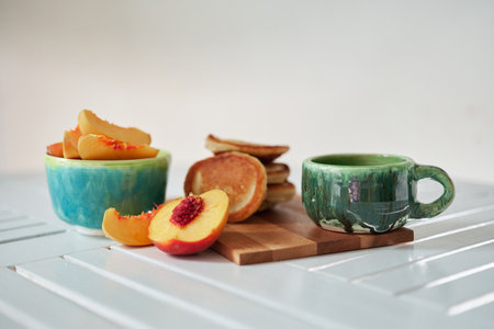 Simple, sweet and Tasty breakfast. Pancake on a wooden plate with peach and coffee in a beautiful...