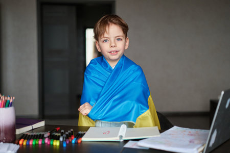 Little boy smiling holding a yellow and blue flag Ukraine. Ukrainian child. Independence Day of Ukraine. Flag Day. Immigration and refugees help High quality photoの写真素材