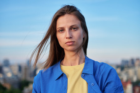 Young female dressed in national colours of Ukraine on the Kyiv city scape. Independent concept, support Ukraine, stop war. High quality photoの写真素材