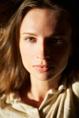Beautiful young female in soft home wear relaxing n the coach in sunset light . Weekend, happiness, cozy concept . High quality photoの写真素材