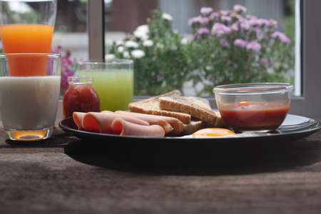 breakfast with scrambled eggs, toast, juice and milkの写真素材