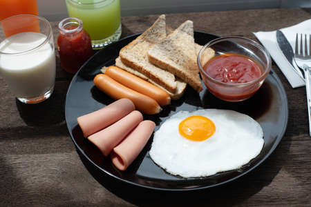 breakfast with scrambled eggs, toast, juice and milkの写真素材