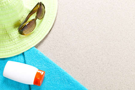 Summer background. Sunglasses suntan lotion hat and towel on beach. Holidays concept with copy spaceの写真素材