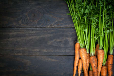 Carrots on wooden table background. Copy space. Top viewの写真素材