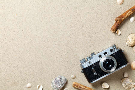 Sand background. Sandy beach texture. Summer concept with old retro camera. Top viewの写真素材