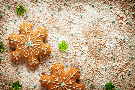 Gingerbreads on snowflakes made %u200B%u200Bof icing sugar on wooden table