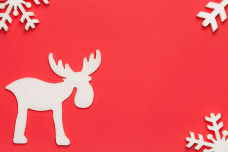 Christmas background with moose and snowflakes on red paper. Top viewの写真素材