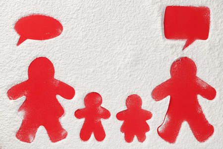 Christmas background with family. Shapes of mother, father, daughter and son on flour red background. Home Xmas concept. Copy space, top view.の写真素材