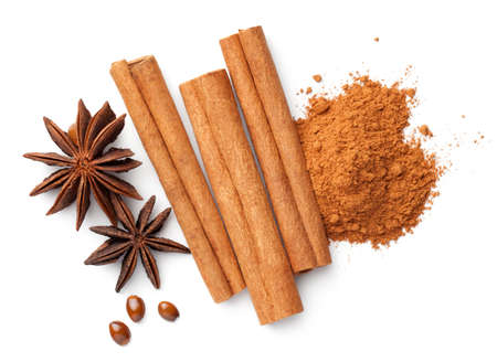 Cinnamon sticks and powder pile, anise stars and seeds isolated on white background. Flat lay. Top viewの写真素材