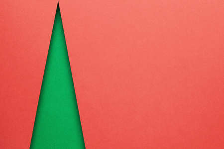 Minimal christmas concept with green shape of christmas tree. Empty room for text on red background. Top viewの写真素材