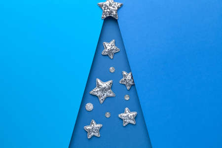 Minimal christmas concept. Blue colored christmas tree shape with silver stars. Copy space. Top view. Flat layの写真素材