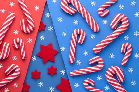 Christmas background. Shape of christmas tree filled by red stars and snowflakes. Candy canes and...
