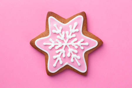 Beautiful christmas gingerbread star cookie with snowflake over pink background