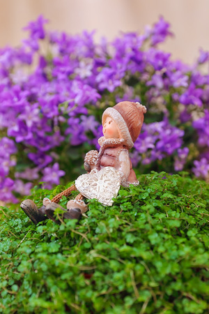 Valentine greeting card with green plant, bell flowers and boy figurineの写真素材