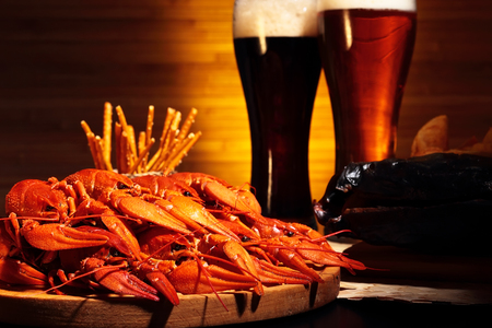Glasses of dark and light beer with crawfish and smoked fishの写真素材