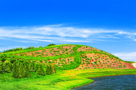 Landscape with green hill on lake beachの写真素材