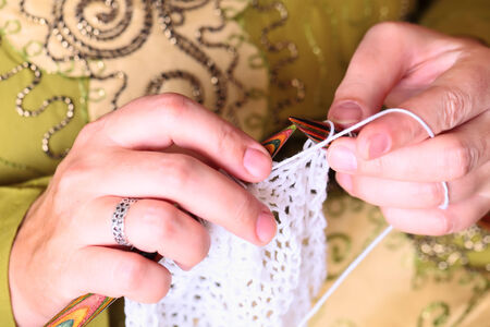 Close-up of woman hands knitting with stylish knitting needles