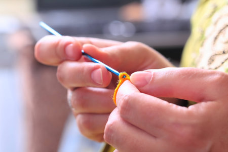 Close-up of woman hands crochet with wool thread