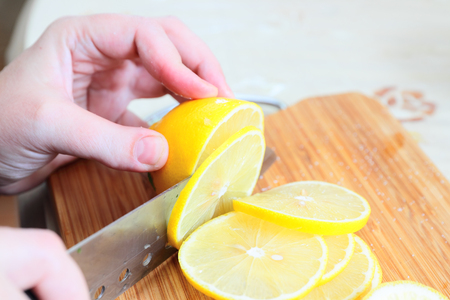 Preparing fresh homemade lemonade, chopping the lemonの写真素材