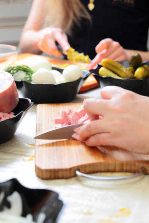 Preparing russian traditional salad Olivier, chopping sausageの写真素材