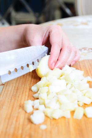 Preparing russian traditional salad Olivier, chopping potatoの写真素材