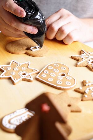 Woman decorating gingerbread cookies. Close up view with selective focus.の写真素材