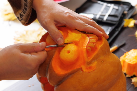 Process of carving out a pumpkin to prepare halloween lanternの写真素材