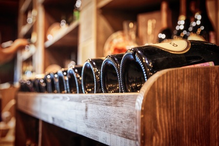 Bottles of red wine on a wooden shelfの写真素材