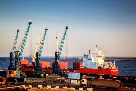 Dudinka, Russia - 10 July, 2013, Cargo freight ship with working crane, loading process