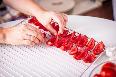 Preparing dried tomatoes: laying of sliced tomatoes