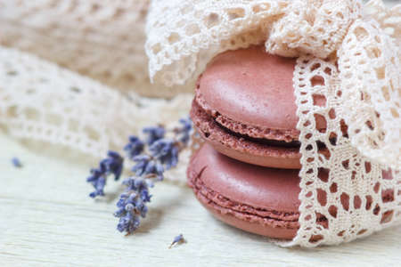 pastel colored macaroon with vintage lace ribbon bow and lavender on paper backgroundの写真素材