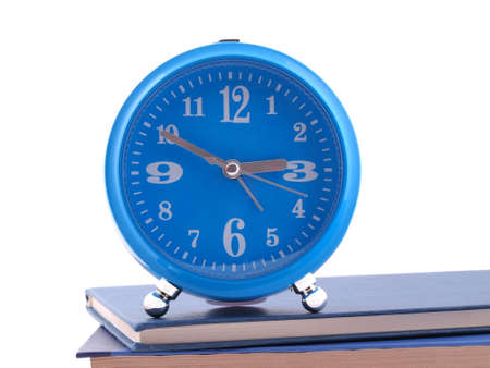 The blue alarm clock standing on blue books   