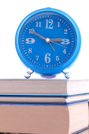 The blue alarm clock standing on books の写真素材