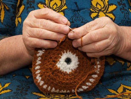 Hands of the elderly woman knitting by means of a hookの写真素材