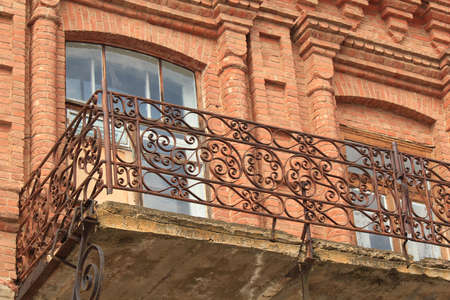 Fragment of the old metal balcony in the old brick houseの写真素材