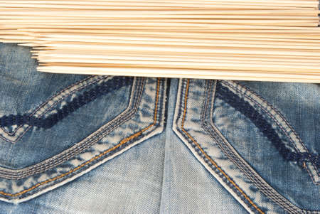 Jean cloth with pockets, seam and stitch and wooden chopsticks as textureの写真素材