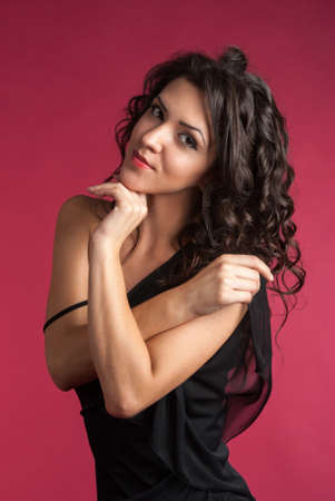 Portrait of beautiful girl looking at the camera, young pretty woman on red backgroundの写真素材