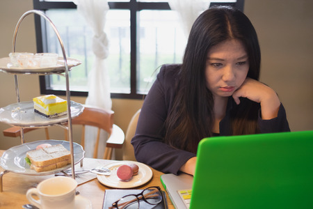 A woman and computer with thinking face at tea time
