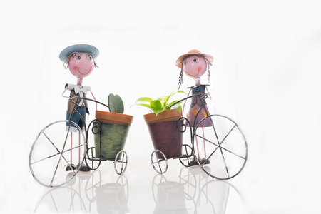 Small plant in heart shape with boy and girl doll of galvanized iron flower pot on isolated backgroundの写真素材